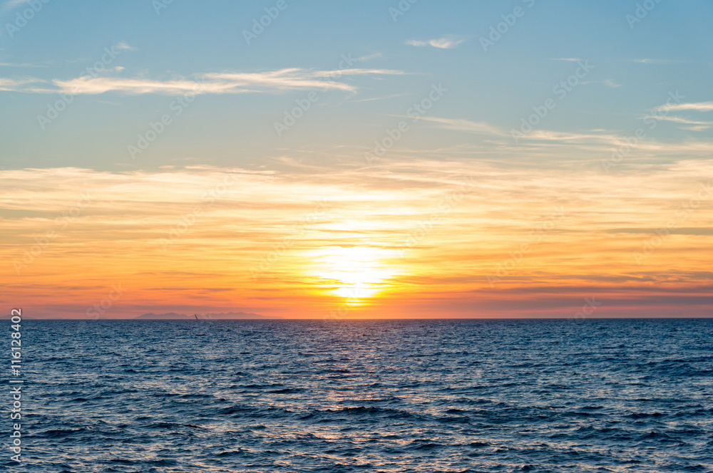 Abstract nature background of colorful sunset sky and calm sea with distant view of Corsica. Italy