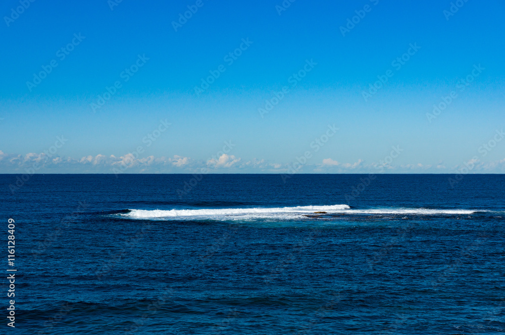 Abstract nature background of clear blue sky and calm sea with distant wave. Australia, Pacific ocean