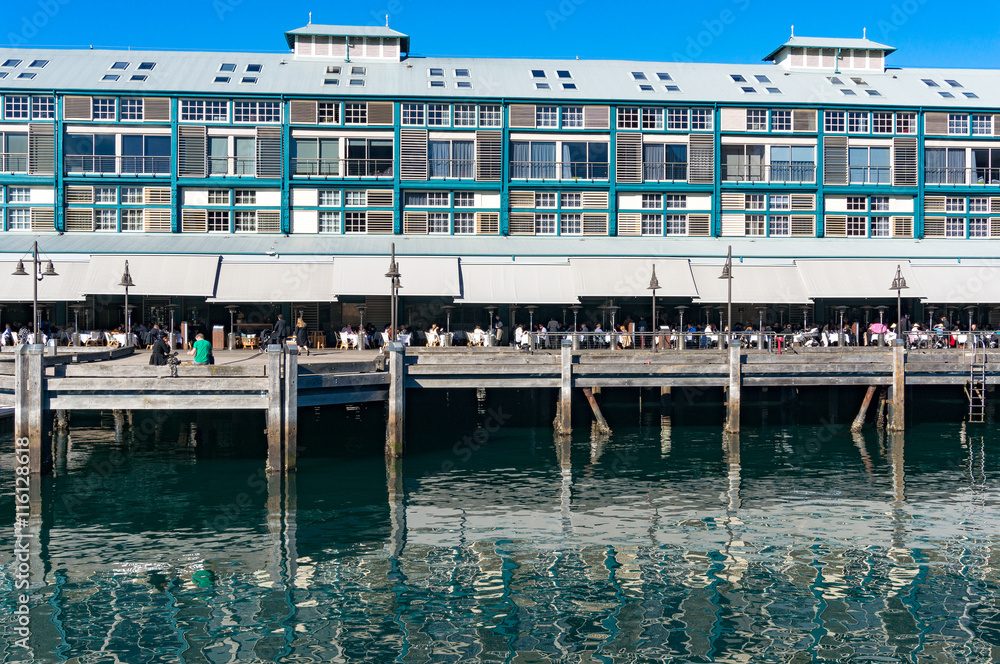 Finger wharf restaurant in Woolloomooloo bay with unrecognisable people in the distance. Sydney, Australia
