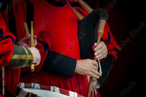 Closeup of the hands of a medieval court musicians playing the drums and bagpipes