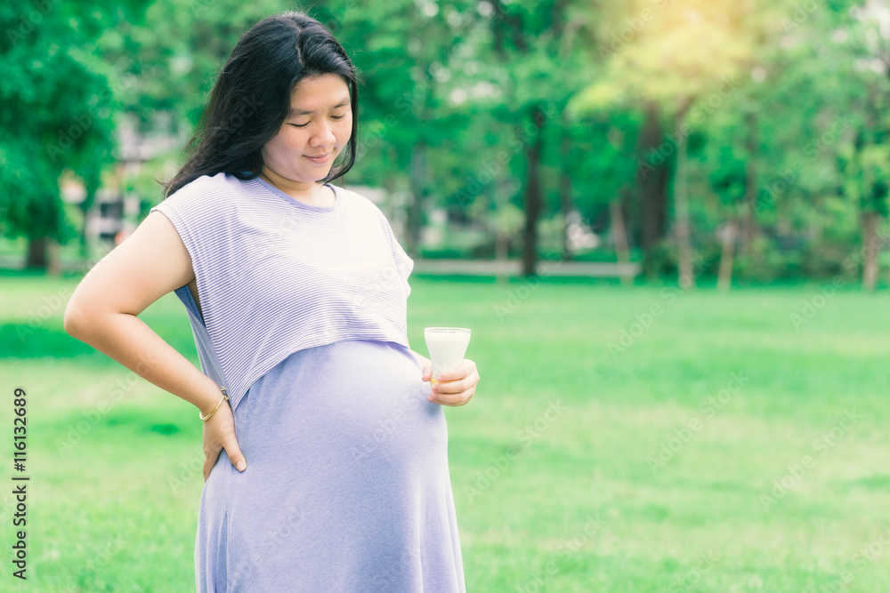 Pregnant woman holding organic milk with a copy space. (Vintage tone) Pregnant woman holding organic milk with a copy space. (Vintage tone)
