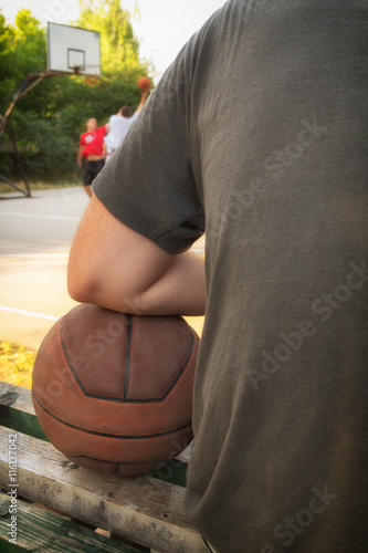 Basketball player making pause on the bench.
