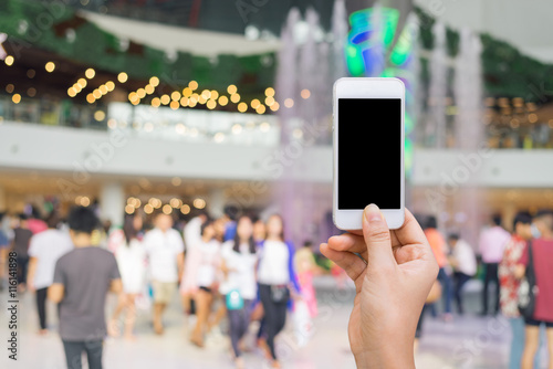 Wallpaper Mural Smart phone with white screen in hand on blurred in shopping mall background,shopping online concept,shopping by smart phone Torontodigital.ca