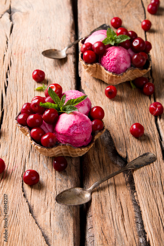 Ice Cream sour cherry, summer sundae with fresh fruits on wooden background. 