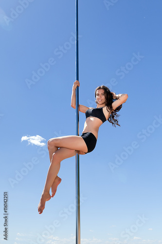 brunette in swimsuit on pylon for dancing