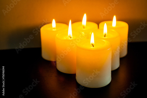 closeup to burning candles in darkness