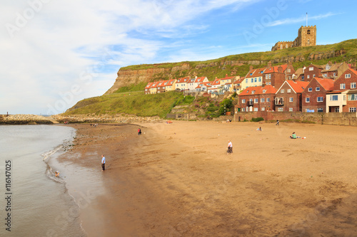 WHITBY, ENGLAND - JULY 16: Various people on the beach, young boy playing in the edge of the sea. In Whitby, North Yorkshire, England. On 16th July 2016. © jasonbatterham