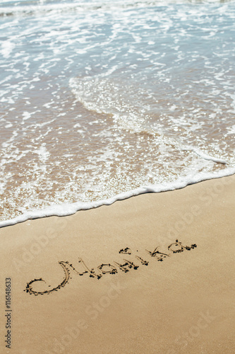 The inscription on the sand seashore. The name on the sand. Against the backdrop the sea waves. © belyjmishka