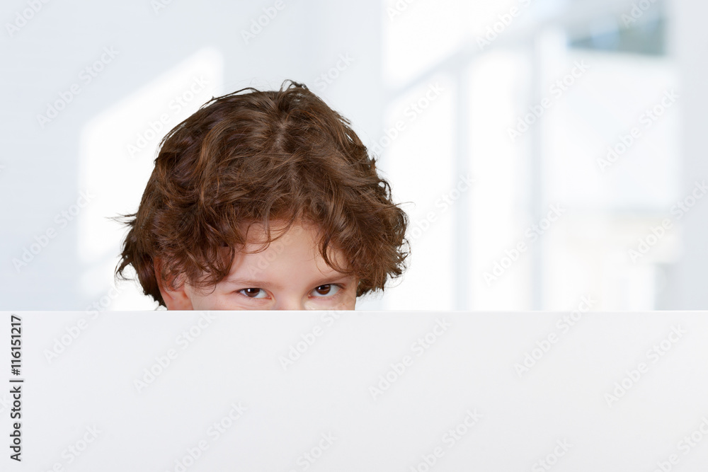 Portrait of cheerful boy pointing on white banner Portrait of cheerful boy pointing on white banner