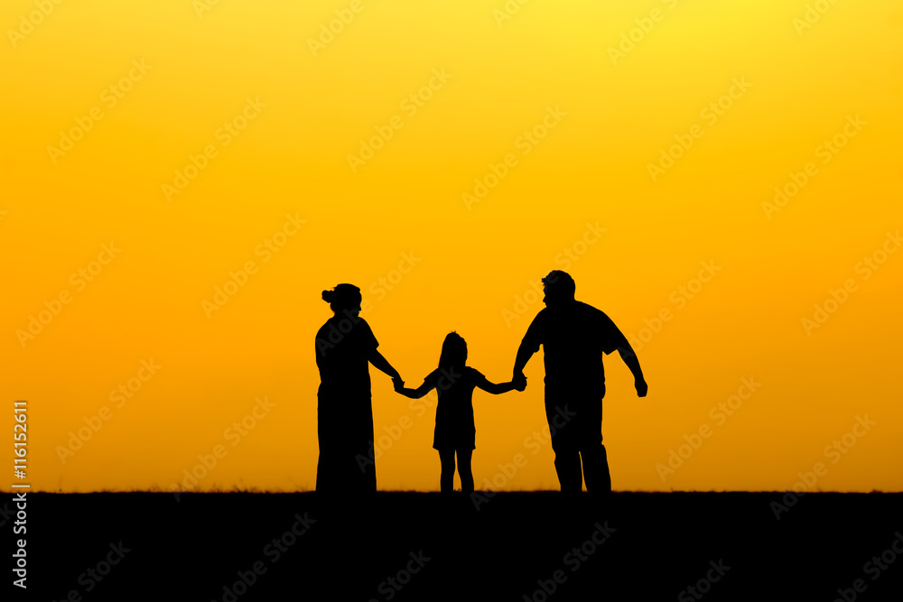 Silhouette of a family walking in sunset