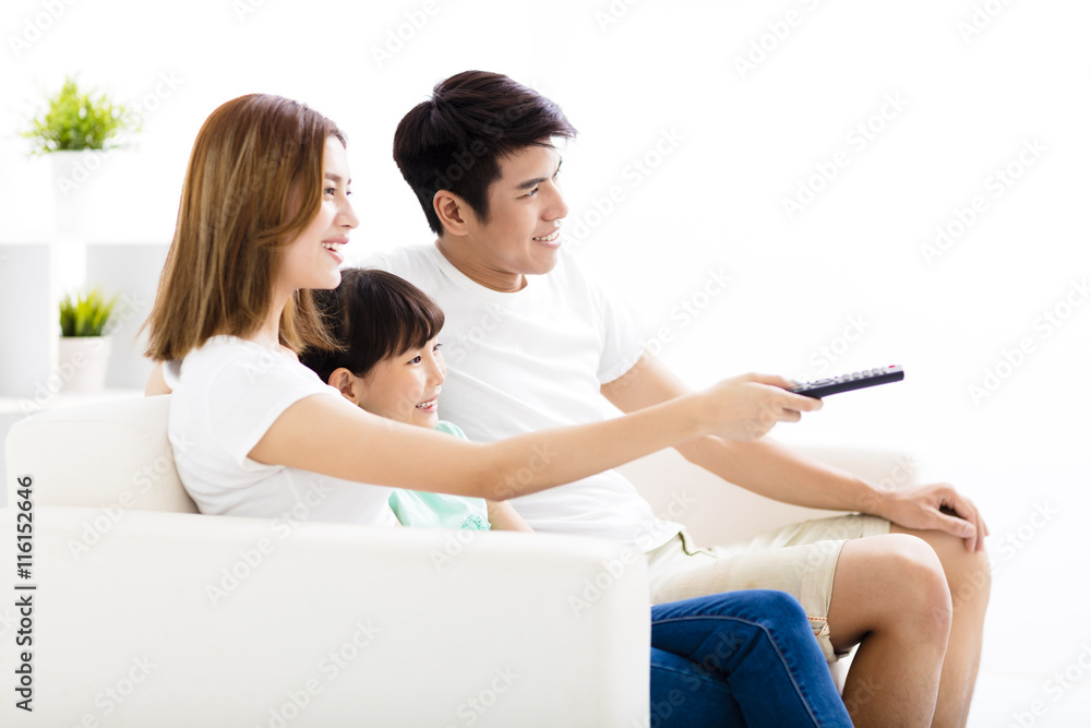 Fototapeta premium Happy Attractive Young Family watching the tv
