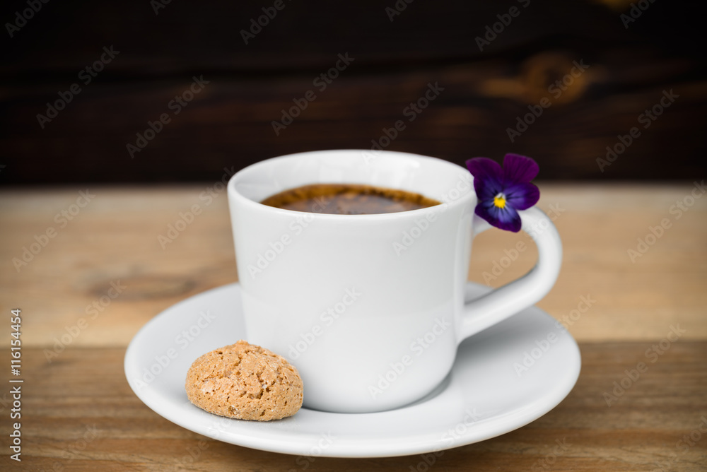 Obraz premium Cup of espresso with biscotti on wooden table