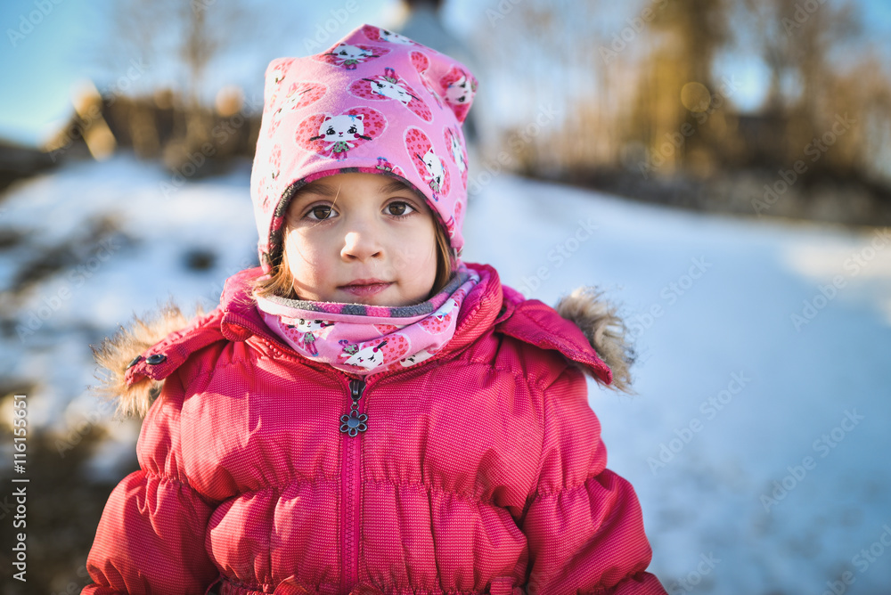 Little girl in winter clothes standing in mountain ski resort Little girl in winter clothes standing in mountain ski resort