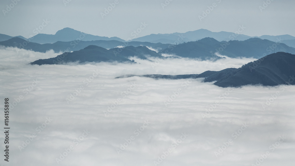 Over the clouds and fog among mountain summits landscape