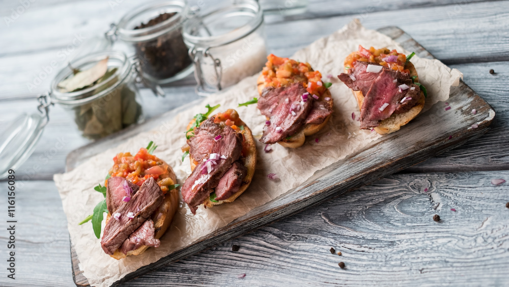 Sandwiches with meat. Mixture of cooked vegetables. Chopped onion on bruschetta. Juicy veal and fresh arugula. Sandwiches with meat. Mixture of cooked vegetables. Chopped onion on bruschetta. Juicy veal and fresh arugula.