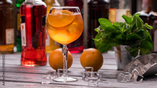Orange drink in wineglass. Ice cubes and oranges. Recipe of Aperol spritz. Tastiest cocktail in our bar. photo