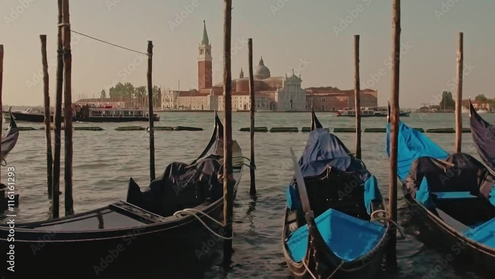 Parked gondolas on Piazza San Marco and The Doge's Palace embankment with the bell tower of the Saint Giorgio Maggiore Church on background in slow motion. Parked gondolas on Piazza San Marco and The Doge's Palace embankment with the bell tower of the Saint Giorgio Maggiore Church on background in slow motion.