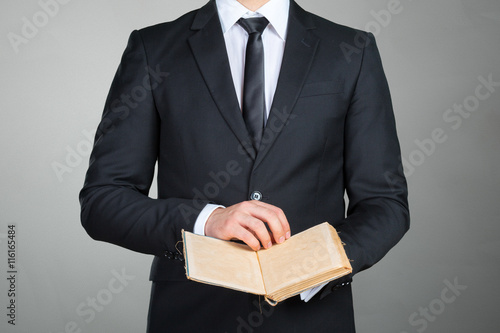 Unrecognizable businessman holding a book closeup