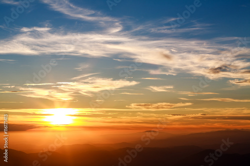 Magnificent sunset sky over silhouette of the mountains