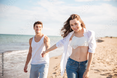 Couple smiling and walking on the beach