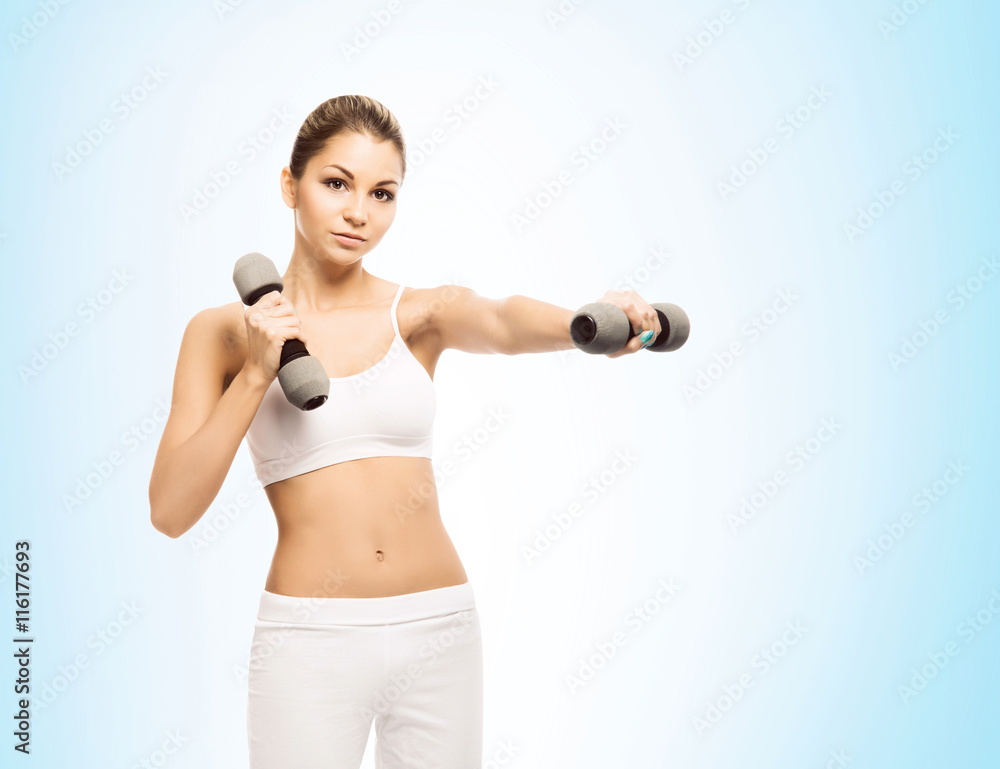 Young and fit woman training with dumbbells Young and fit woman training with dumbbells