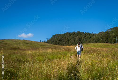 Guy and girl walking through field