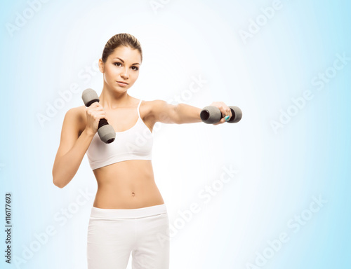 Young and fit woman training with dumbbells