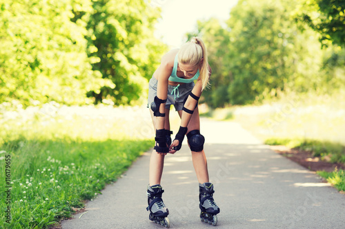 happy young woman in rollerskates riding outdoors