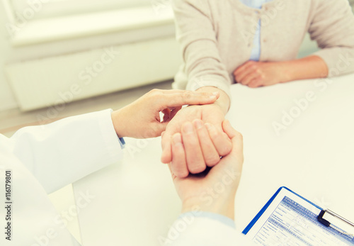 doctor checking senior woman pulse at hospital