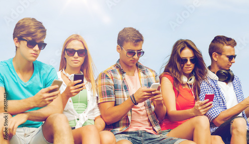group of friends with smartphones outdoors