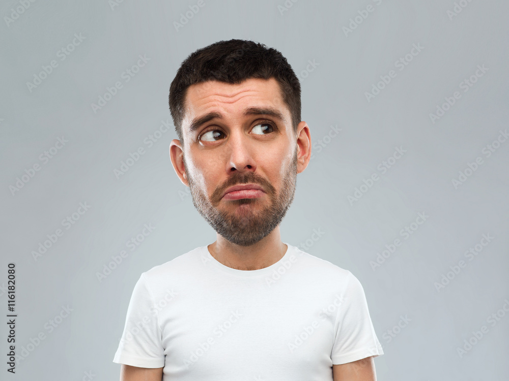unhappy young man over gray background unhappy young man over gray background