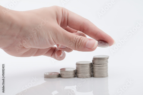 puting a coin on piles of coins photo