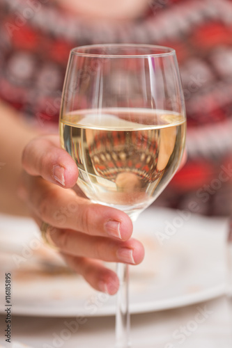 Woman holding a glass of white wine during lunch