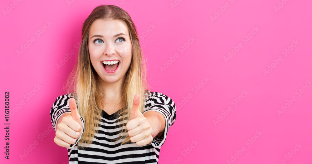 Happy young woman giving thumbs up