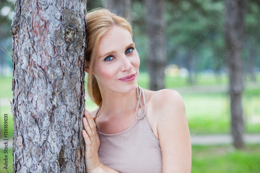 Beautiful blonde with blue eyes enjoying a walk in the forest Beautiful blonde with blue eyes enjoying a walk in the forest