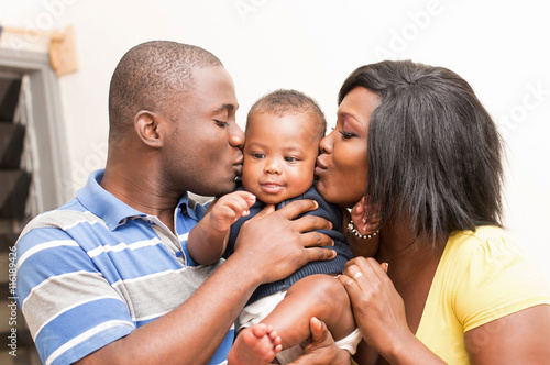 Konstfotografi portrait  de couple heureux embrassant tendrement leur bébé