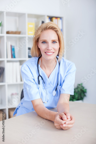 Young female doctor and practitioner working at desk