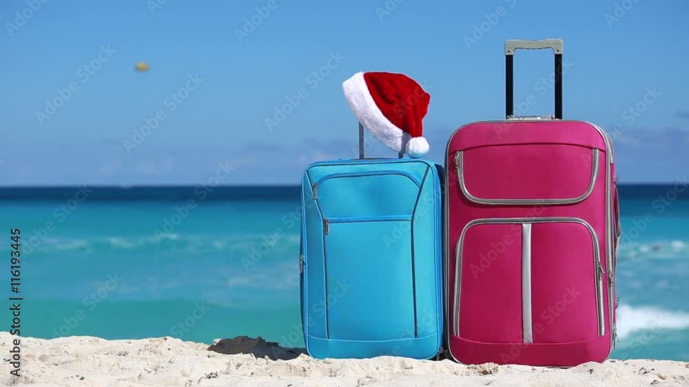 Santa Claus hat on suitcase at tropical sandy beach. New Year and christmas celebration
Santa Claus hat on suitcase at tropical sandy beach. New Year and christmas celebration