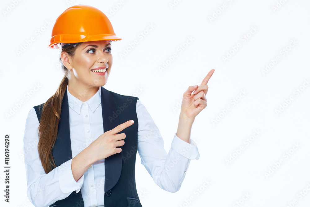 Woman builder in helmet points finger at copy space Woman builder in helmet points finger at copy space