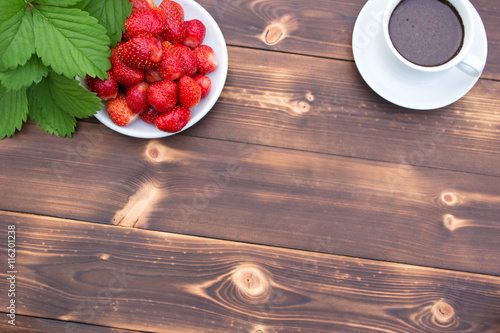 Strawberries and a Cup of coffee on a wooden table
