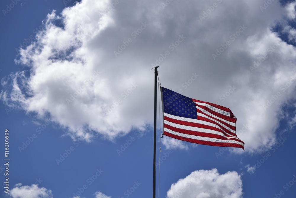 An American flag waving in the clouds. An American flag waving in the clouds.