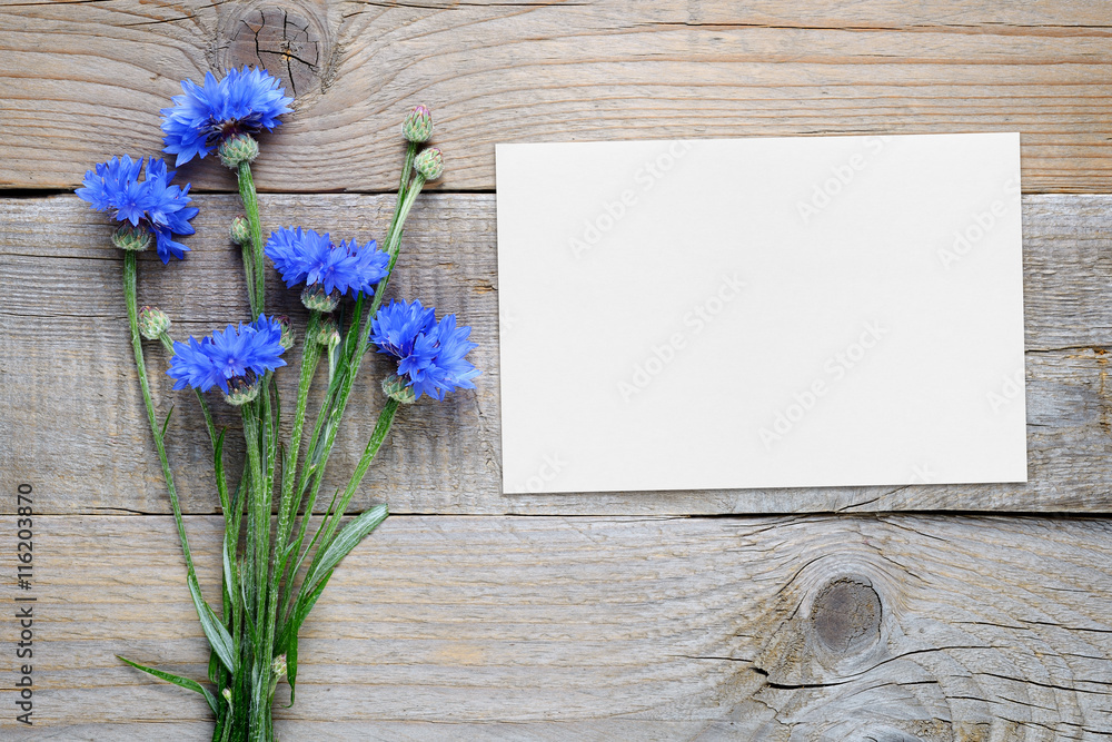 Cornflowers and blank card on wooden background Cornflowers and blank card on wooden background