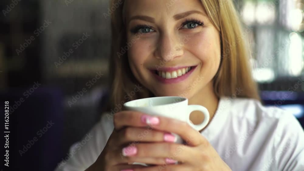 Close-up portrait, pretty young beautiful blond woman with white cup of coffee Close-up portrait, pretty young beautiful blond woman with white cup of coffee