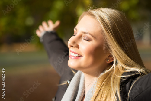 junge blonde Frau genießt die Herbstsonne