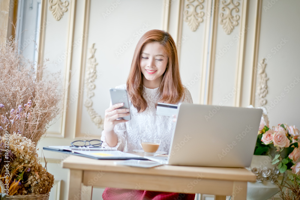 Happy woman shopping online, holding credit card. Happy woman shopping online, holding credit card.