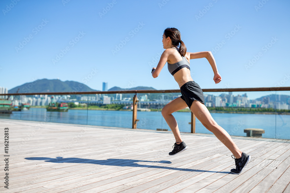 Back view of woman running in City