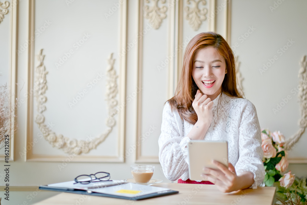 Woman with laptop watching fun movie on tablet Woman with laptop watching fun movie on tablet
