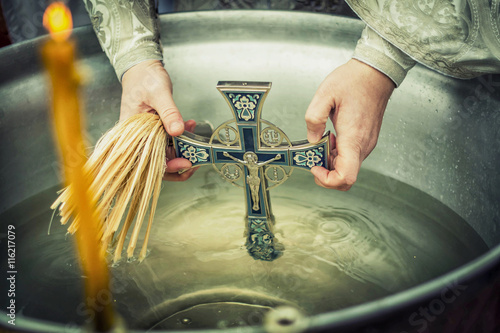 baptism, Orthodox feast, the Christian feast of the baptism, the cross in Holy water, Holy water in a tub with a cross and the hands of the priest