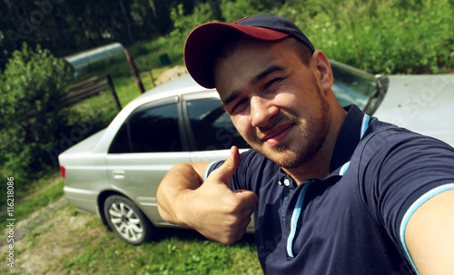 Man is taking a selfie on the car background