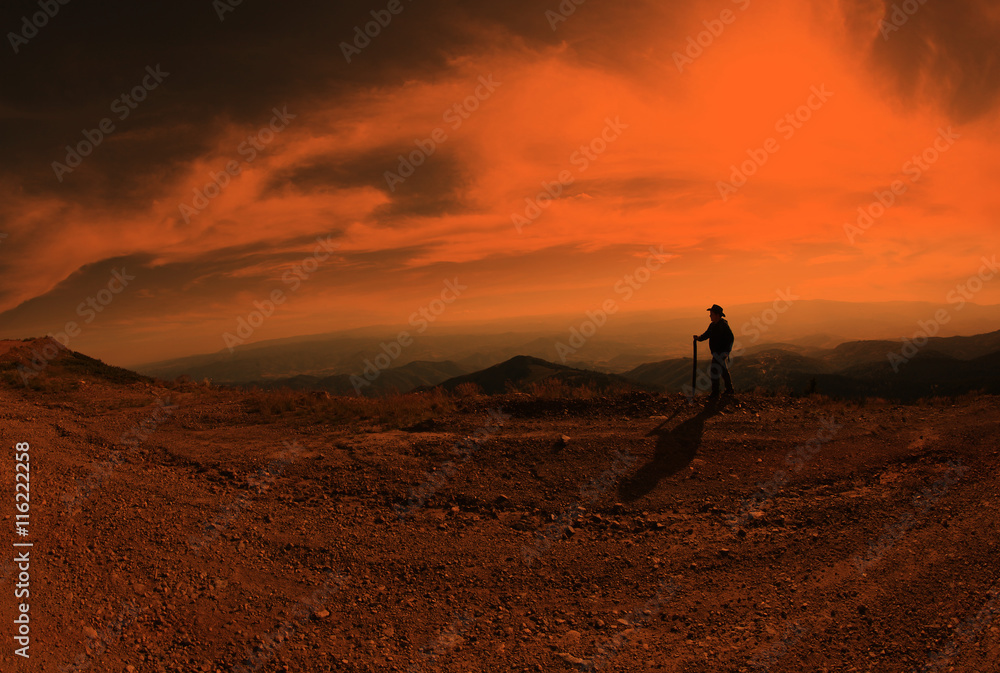 Boy is hiking on beautiful mountain sunset
